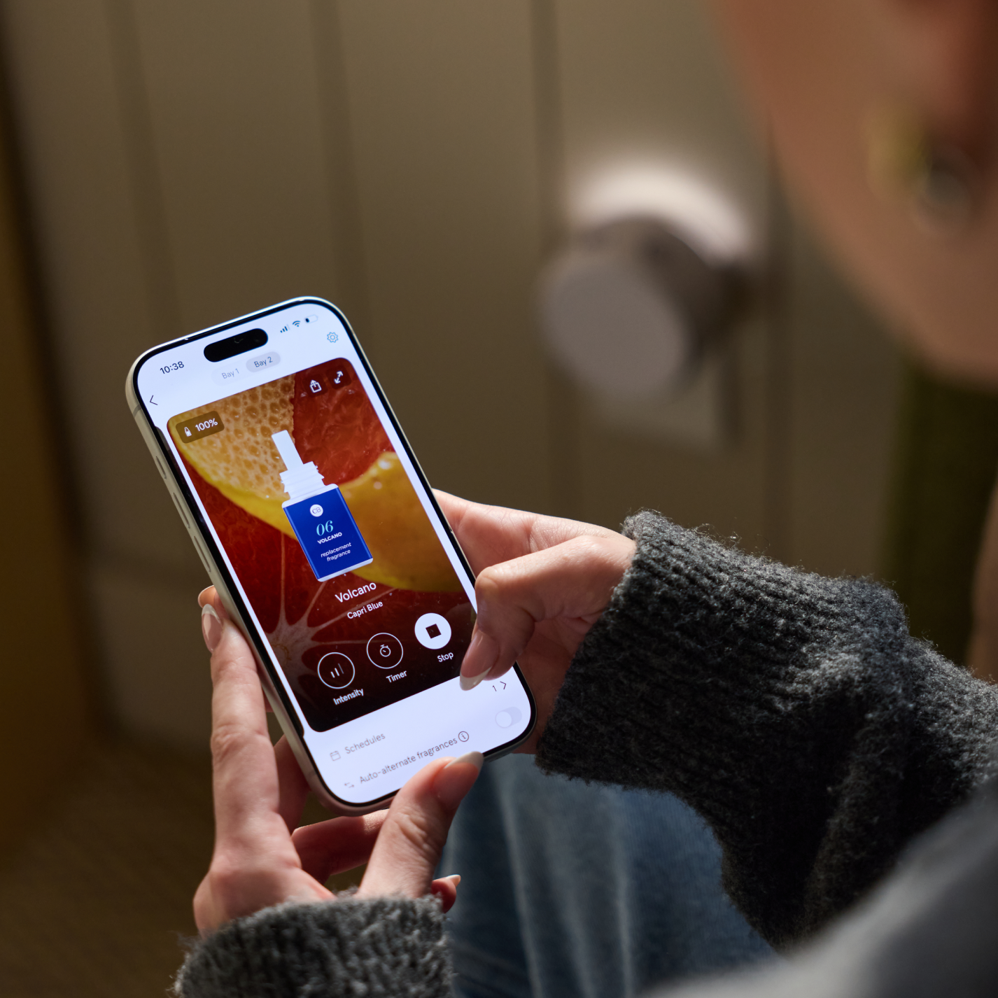 Person controlling Pura smart diffuser with Capri Blue Volcano scent in the Pura app